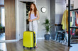 © alfa27 - adorable female move in new apartment, shine with happines, redhead female waited a long time to move, stand with yellow buggage and examine the room, she is inspired