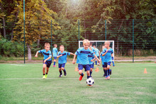 Kids Running And Kicking Soccer Balls On Children Football Training Session And Improving Game Skills