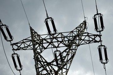 The head of a high voltage power pole with wires as seen from the ground.