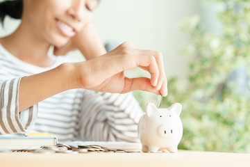 Wall Mural -  Happy Asian woman saving money in piggy bank For future scholarships