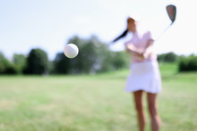 Golf Ball Against Background Of Hitting Woman Closeup. Active Healthy Lifestyle Concept