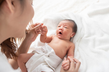 Poster - woman and new born boy relax. mother breast feeding baby. family at home. happy mother and baby. young mother holding her newborn child. mom nursing baby. mother and baby child on a white bed.