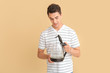 © Pixel-Shot - Young man with electric kettle on color background
