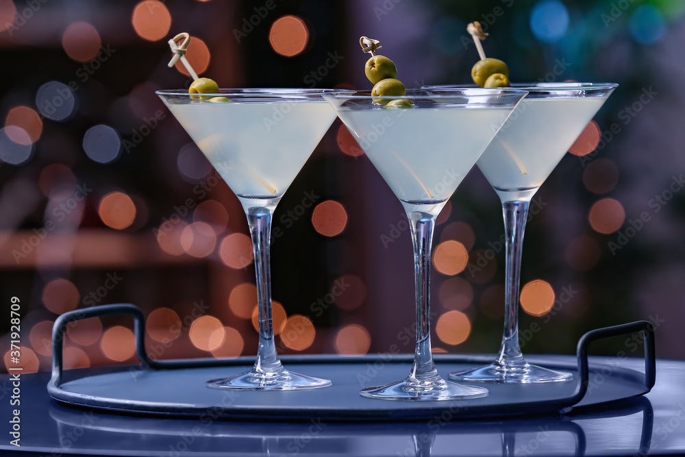 Glasses of fresh martini on dark background