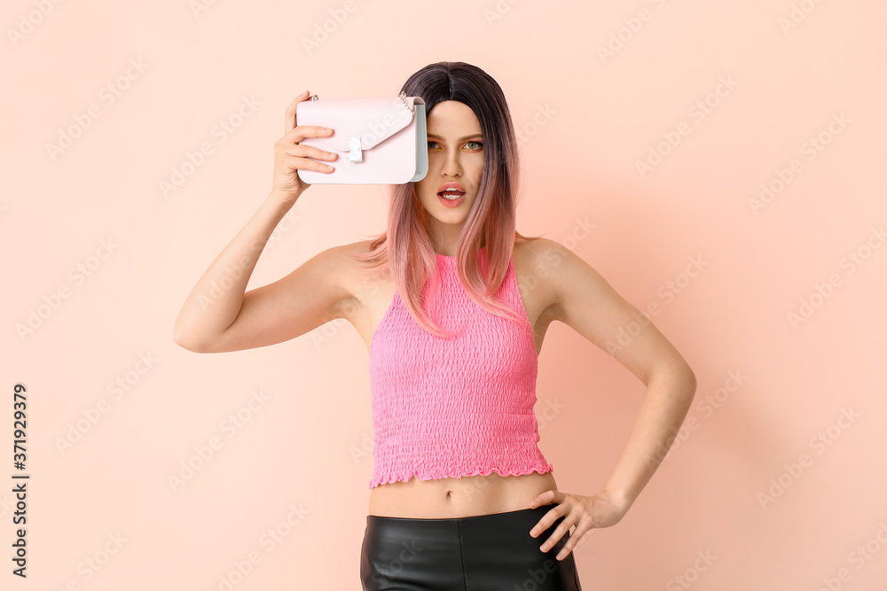 Beautiful young woman in wig on color background
