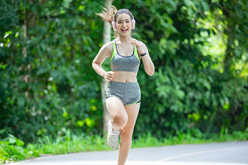 Beautiful Asian girls fitness runner running on a trail On roads and running in parks or nature trails