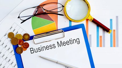 Poster - Workspace office desk - text BUSINESS MEETING on the charts
