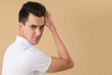 Wall Mural - Handsome man with stylish hairdo on color background