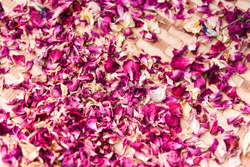 Sticker - Pink rose petals to dry on wood background , top view - dried rose petals