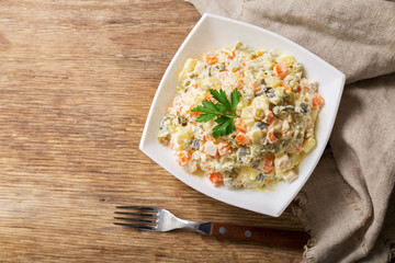 bowl of russian salad olivier with meat and vegetables, top view