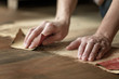 Womens hands sanding the wood floor before painting. Housework. Repairs