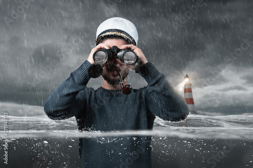 Cuadros en Lienzo shipwrecked helmsman watching with binoculars the rock in the water and standing