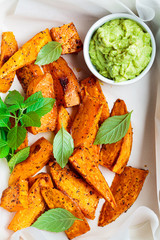 Wall Mural - Baked sweet potato wedges with guacamole. Healthy vegan food concept.