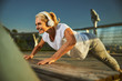 Cheerful woman doing bench push-ups during morning workout