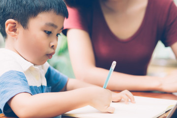 Wall Mural - Son using digital tablet computer for study and learn to internet online with mother together, education from home, family recreation, mom teach boy and homework with technology, lifestyle concept.