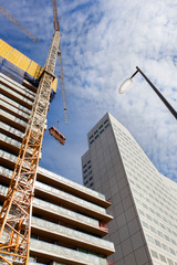 Construction site with two cranes hoisting construction material in Rotterdam in the Netherlands