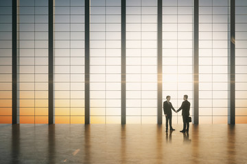 Poster - Businessmen shaking hands in large office with sunrise view.