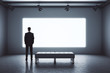 Businessman standing in modern exhibition room with blank projection screen