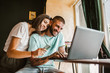 © Mediteraneo - Couple buying online with credit card and laptop in a coffee shop