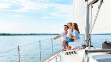Parents And Daughter Sitting On Yacht Deck Sailing Outside, Panorama