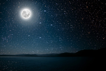 Wall Mural - moon against a bright night starry sky reflected in the sea.