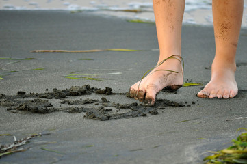 Drawing with a foot on the sand of the beach.