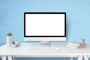 Poster - Modern computer display mockup on work desk. Isolated screen for web site design promotion concept. Blue wall in background