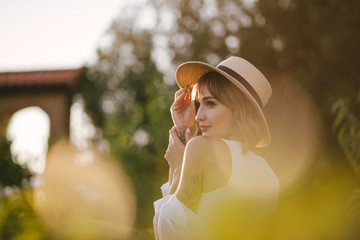 Wall Mural - Young beautiful woman wearing fashionable trendy clothes posing at sunset on sunny summer day.