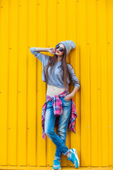 Wall Mural - Beautiful Trendy teen Girl over Yellow Wall