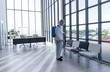 © Pornsak - Disinfecting public place , Staff PPE uniforms suit are using an alcohol sprayer.