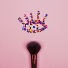 Canvas Print - Closeup of professional cosmetic makeup brush with eye shape made of shiny colorful sparkles on pink background with copyspace for your text, leaflet. Creative make-up concept, square composition