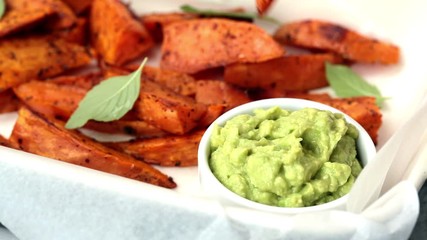 Wall Mural - Baked sweet potato wedges with guacamole. Healthy vegan food concept.