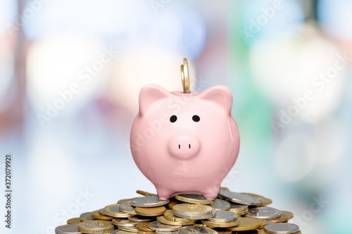 Piggy bank and golden coins on blur background Tableau sur Toile