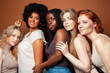 Leinwandbild Motiv young pretty african and caucasian women posing cheerful together on brown background, lifestyle diverse nationality people concept