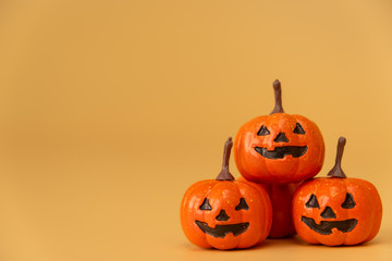 three Halloween Pumpkins on orange background