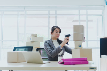 A beautiful businesswoman working at home is checking orders for products to be delivered to her customers from notebooks.