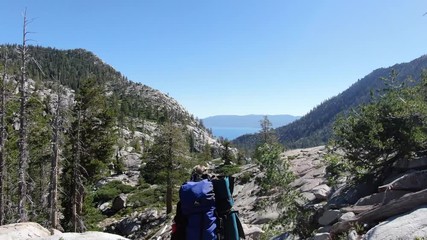 a young woman hikes up a ridge while backpacking and hiking in desolation wilderness in the sierra n