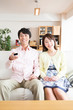 © Paylessimages - テレビを見る夫婦