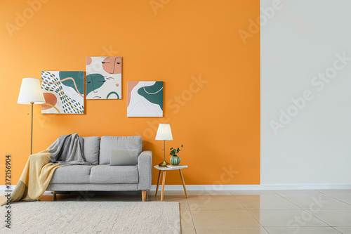 Stylish interior of living room with sofa and lamps Poster Mural XXL