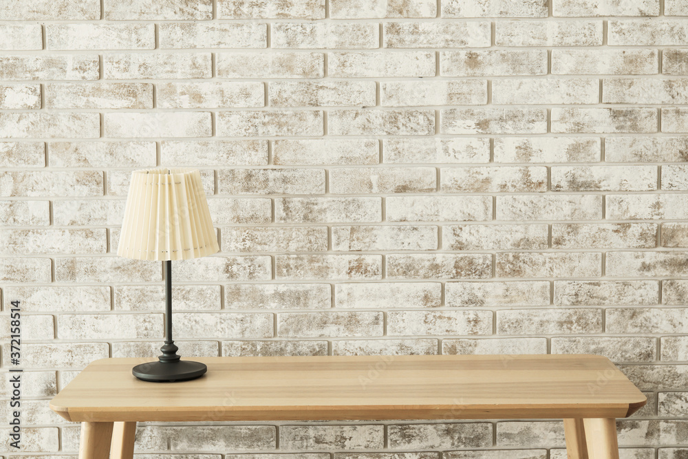 Table with lamp in empty room