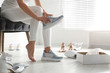 © New Africa - Young woman trying on shoes indoors, closeup