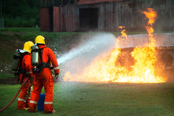 Wall Mural - Firefighters spraying water to put out a brutal fire on the car.