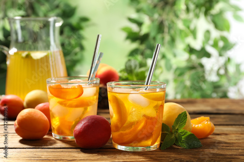 Delicious refreshing drink with apricot on wooden table
