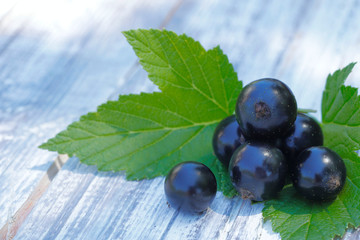 Wall Mural - Black currant berries close-up.
Natural background.Round black currant berries on a wooden table.Horizontal, nobody, free space, side view. Agriculture concept.