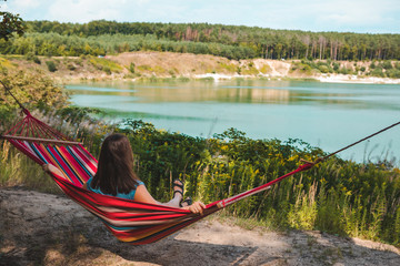 Wall Mural - woman laying on hammock enjoying the view of summer lake