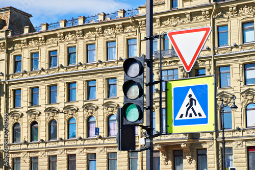 Traffic light and road signs on old city building