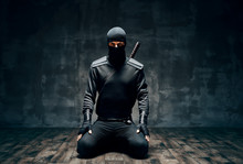 Ninja Kneeling Posing With A Sword Over Black Background