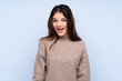 Young brunette woman wearing a sweater over isolated blue background with surprise facial expression