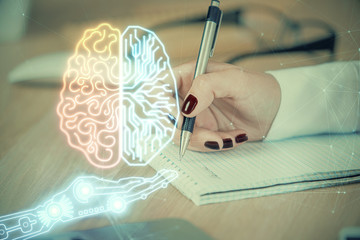 Multi exposure of woman's writing hand on background with brain hologram. Concept of brainstorming.