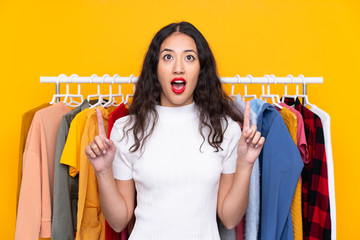 Wall Mural - Mixed race woman in a clothing store pointing with the index finger a great idea